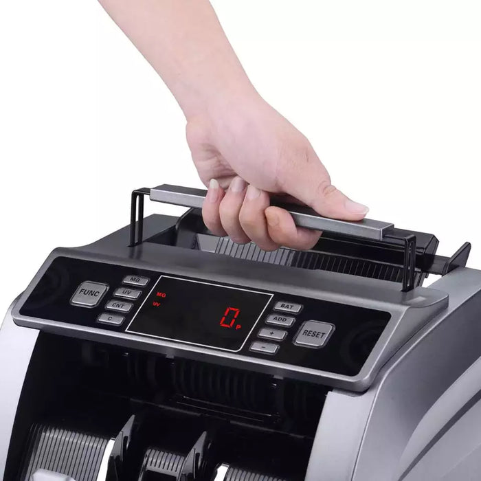 Hand lifting the money counter by its top carrying handle
